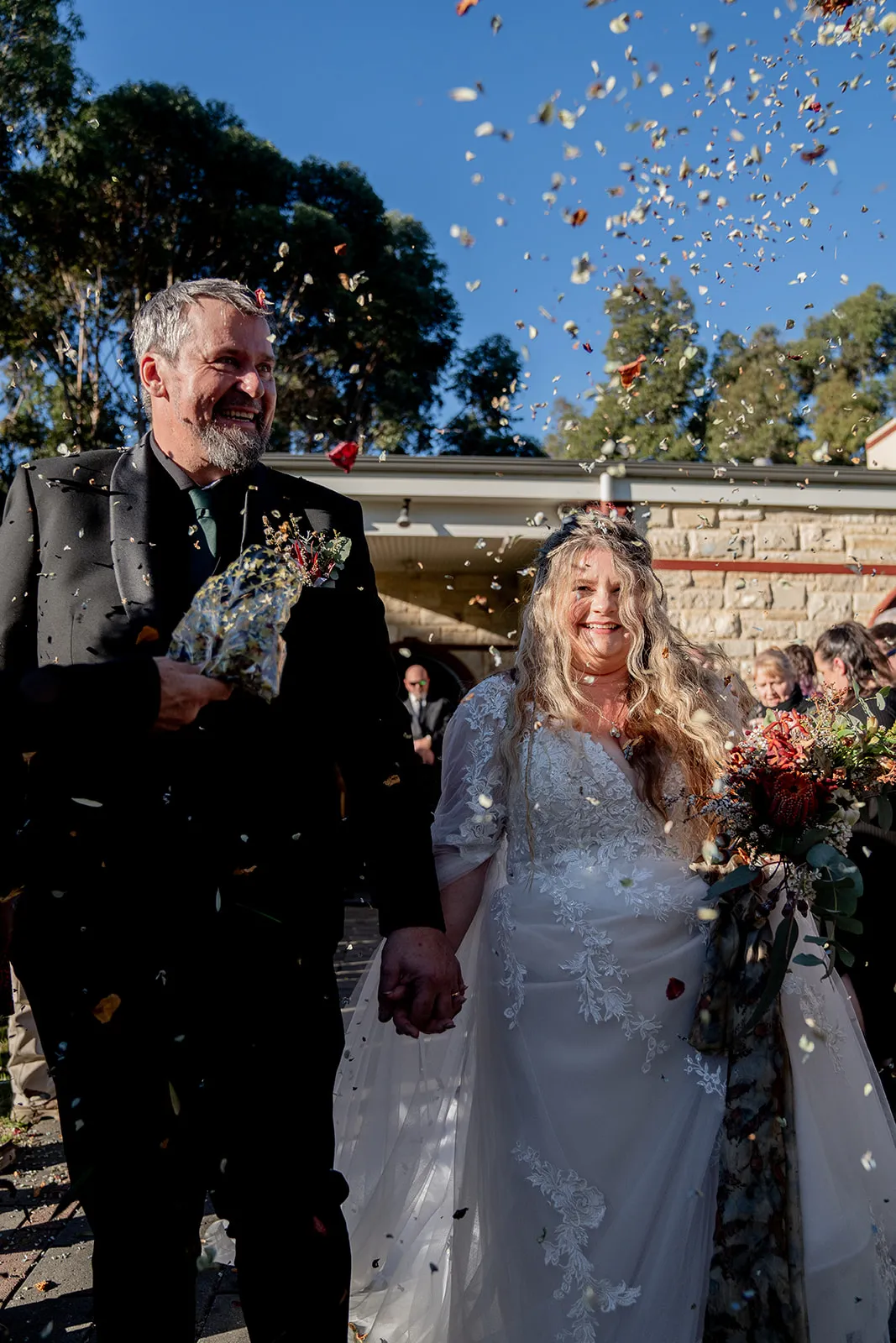 Newlyweds laughing through a confetti exit at their Fleurieu Peninsula wedding