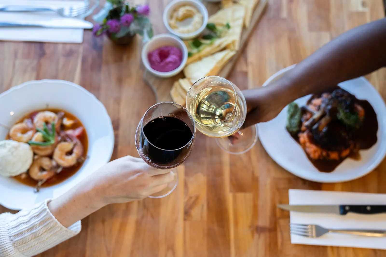 Overhead table spread with a wine toast mid-celebration