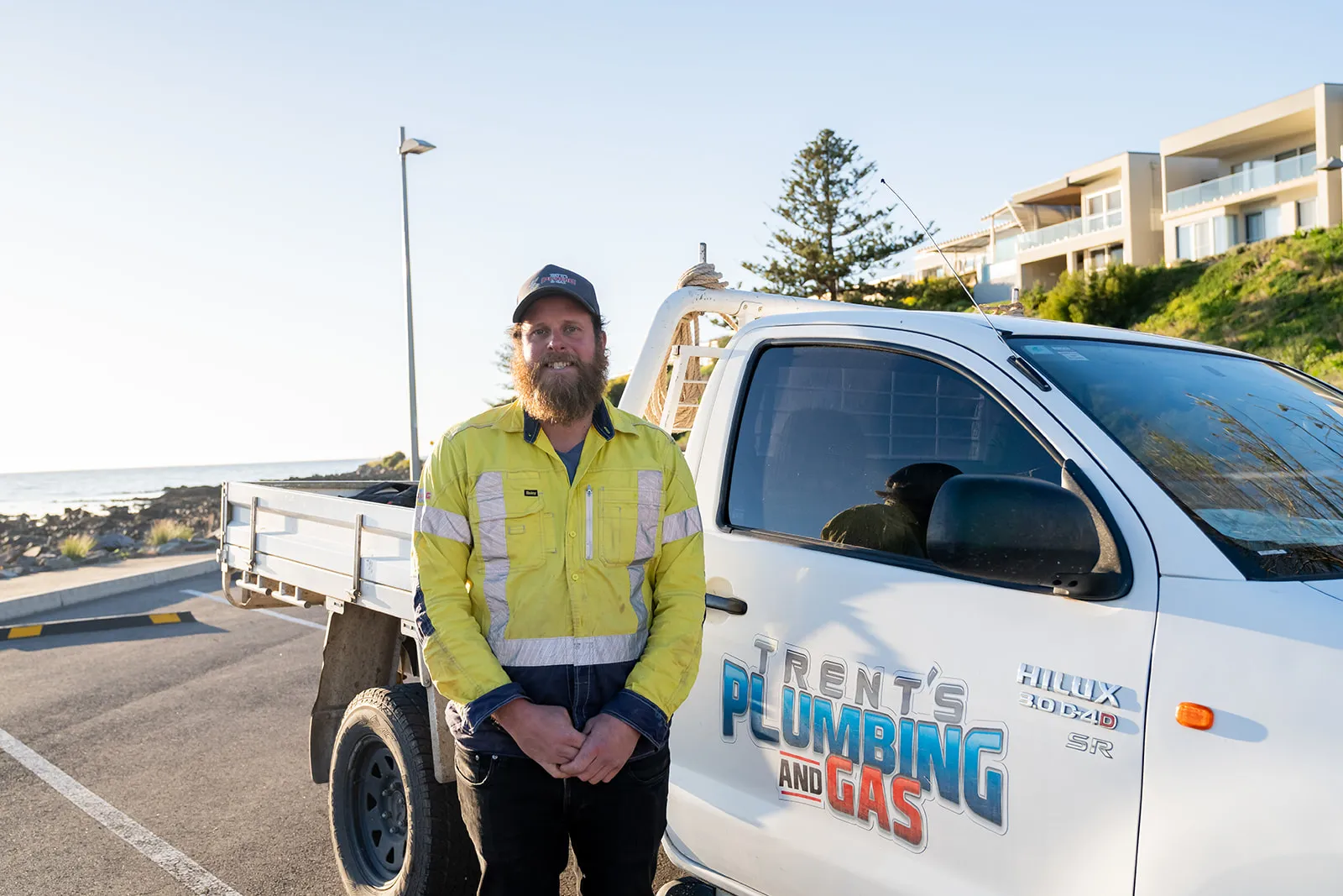Environmental portrait of a plumber with the branded work van