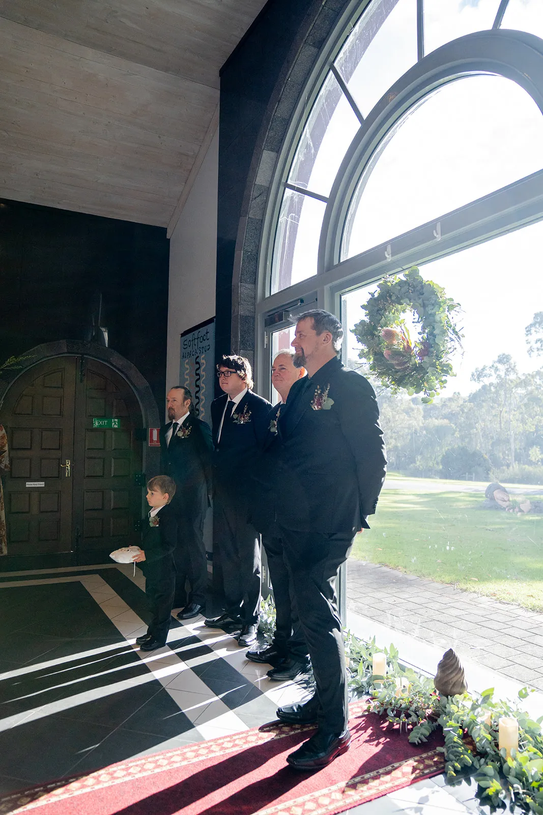 Groom and attendants waiting in soft window light before the ceremony