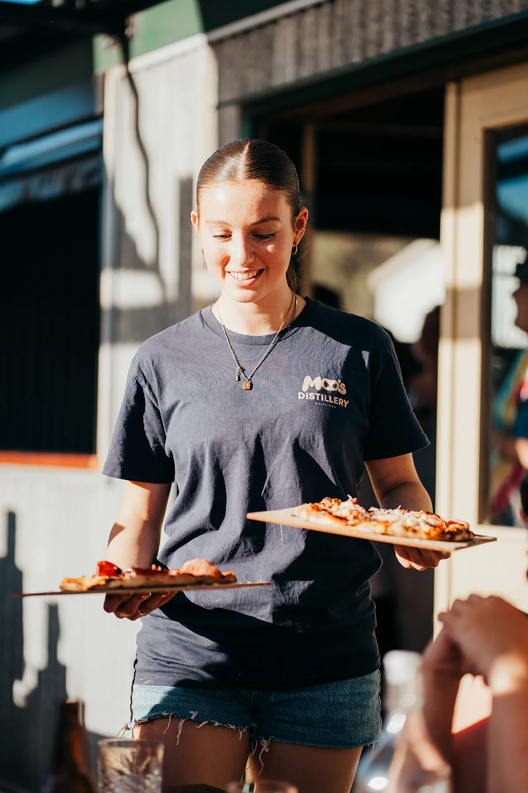 Server carrying food to guests across the lawn