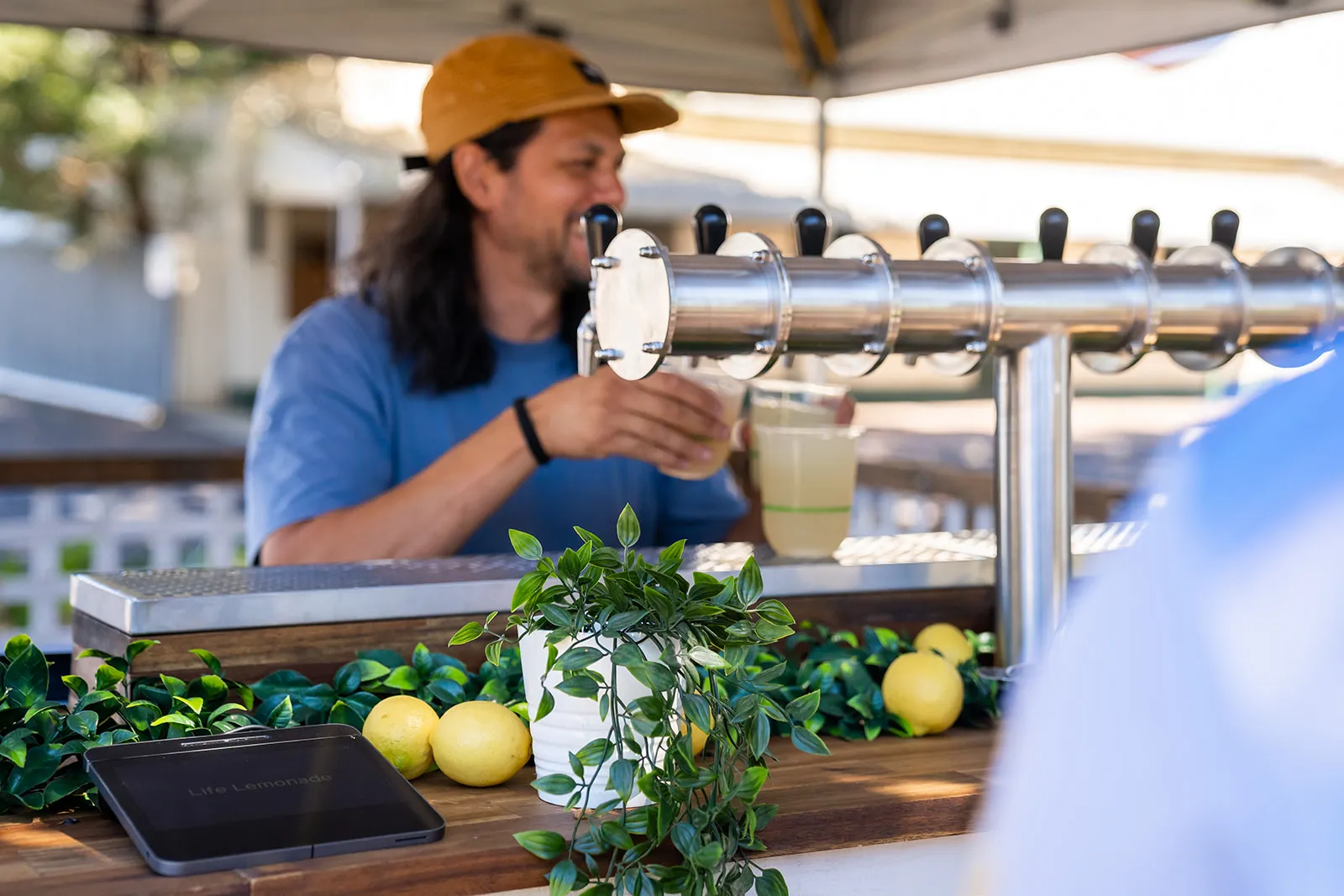 Bar service with taps, fresh lemons and customers at a market stall