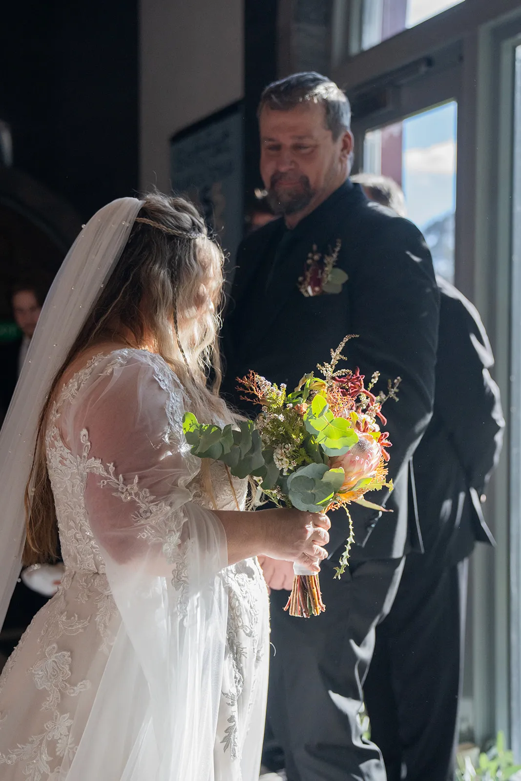 An intimate handoff at the front of the wedding ceremony