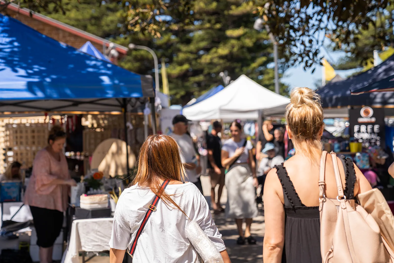 Shaded market lane filled with weekend visitors
