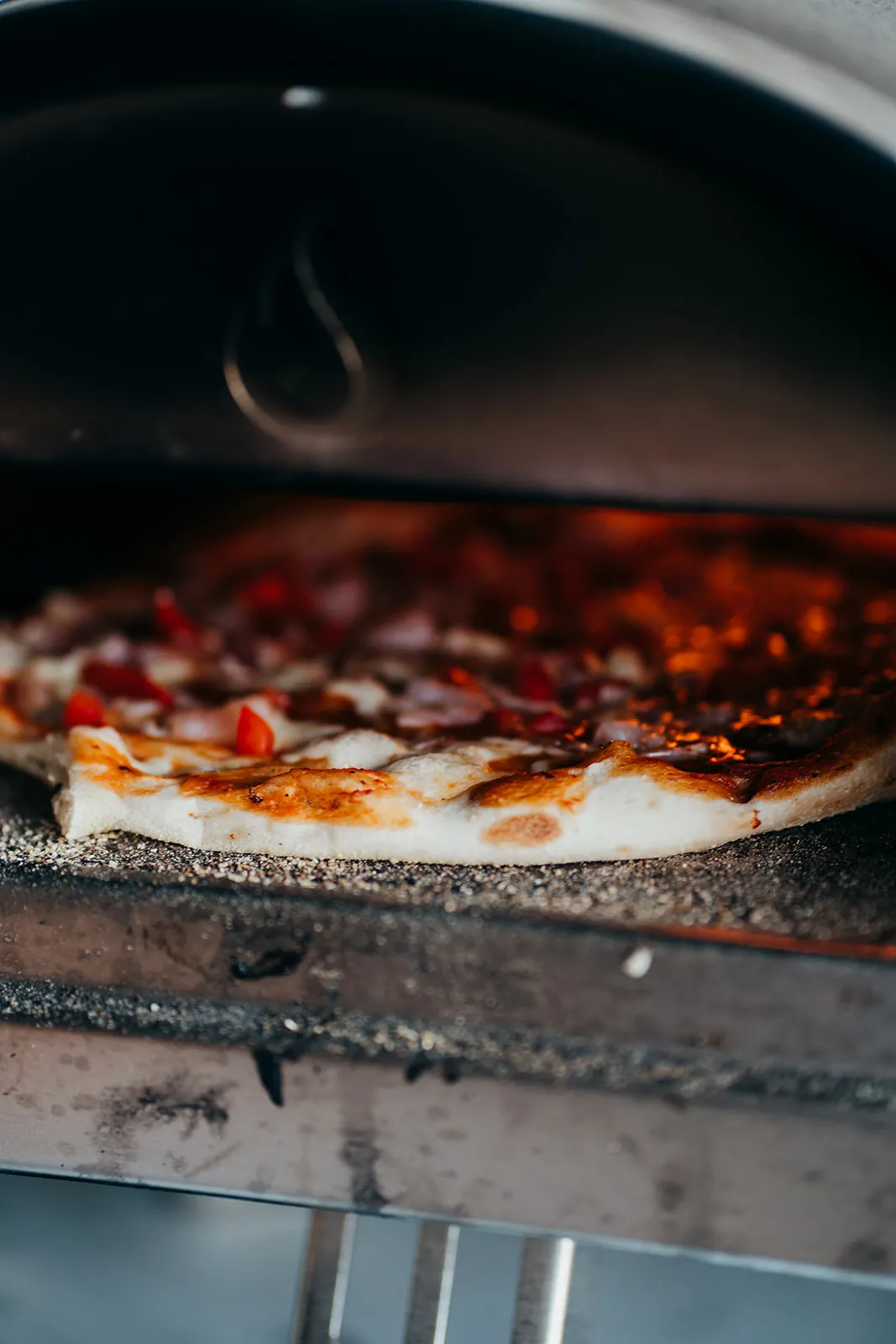 Pizza cooking in the wood-fired oven
